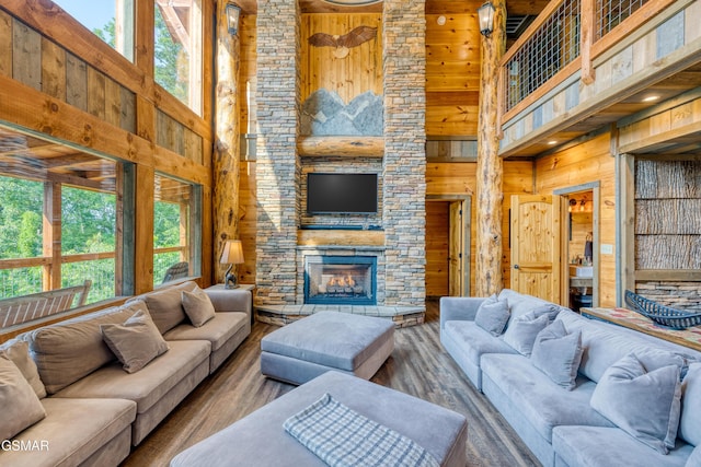 809 Pinecrest Way, Sevierville, TN 37862 - living area featuring a high ceiling, wooden walls, healthy amount of natural light, a stone fireplace, and wood finished floors