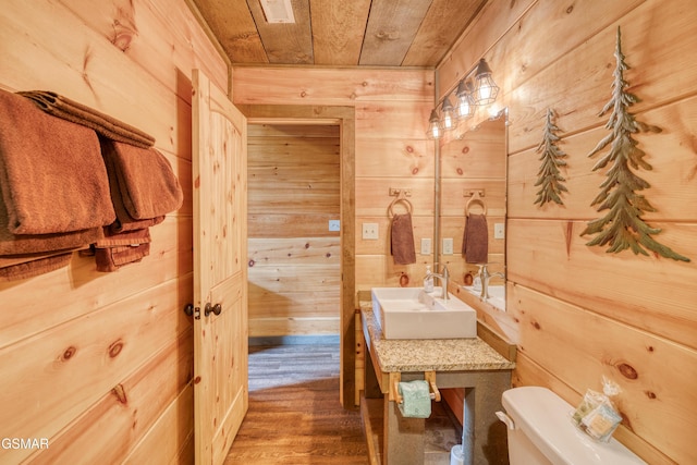 809 Pinecrest Way, Sevierville, TN 37862 - half bath featuring a sink, wood walls, wooden ceiling, toilet, and wood finished floors