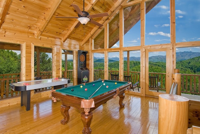 recreation room featuring a mountain view, beamed ceiling, and light hardwood / wood-style floors