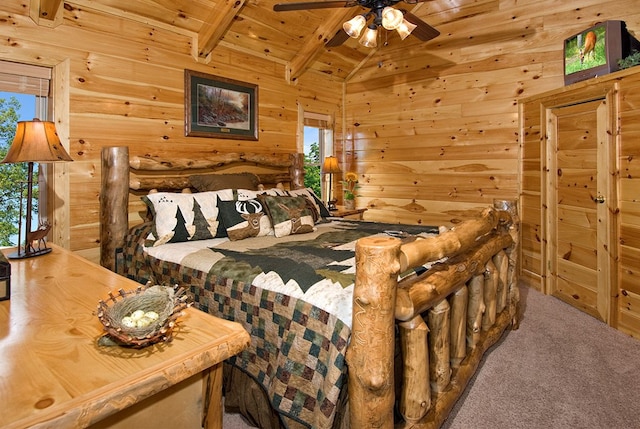 carpeted bedroom featuring lofted ceiling with beams, ceiling fan, wood ceiling, and wooden walls