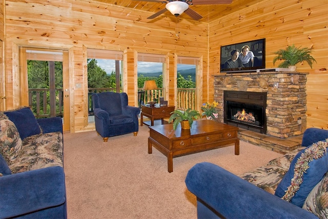 living room with light carpet, ceiling fan, wooden walls, wooden ceiling, and a fireplace