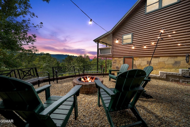 patio terrace at dusk featuring an outdoor fire pit