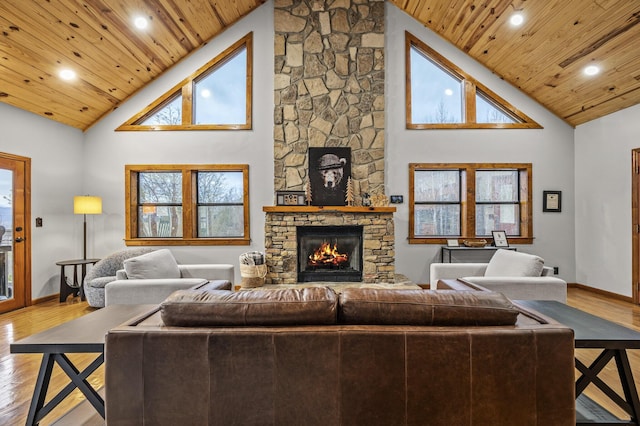 living room featuring a fireplace, light hardwood / wood-style flooring, high vaulted ceiling, and wooden ceiling