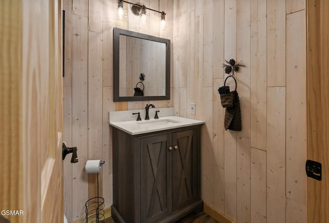 bathroom with vanity and wooden walls