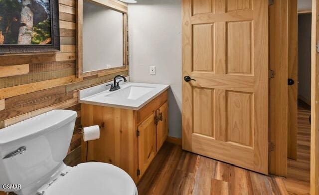 bathroom with toilet, wood finished floors, and vanity