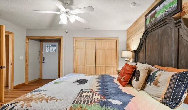 bedroom featuring a textured ceiling, wood finished floors, a ceiling fan, and baseboards