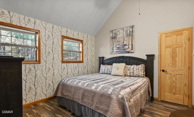 bedroom featuring wallpapered walls, baseboards, vaulted ceiling, and dark wood-type flooring