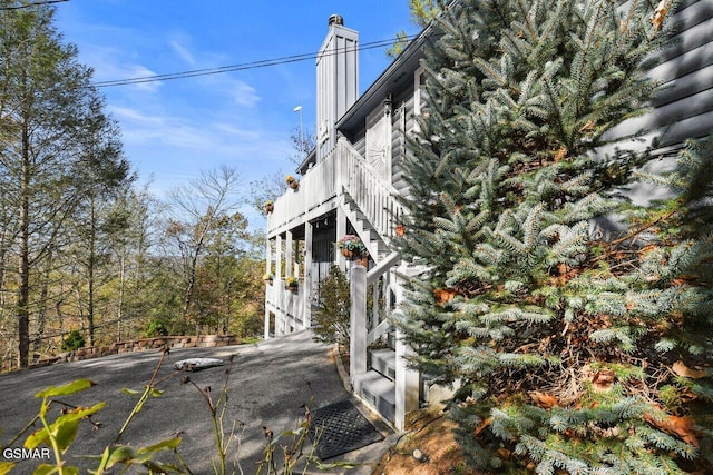 view of side of property featuring stairs and a chimney