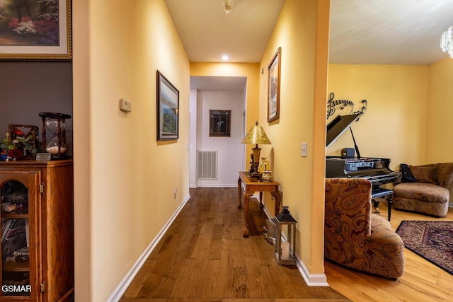corridor with recessed lighting, visible vents, baseboards, and wood finished floors