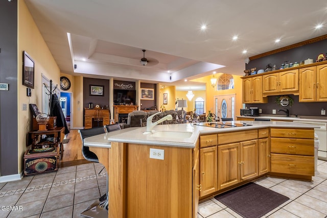 kitchen featuring light tile patterned floors, a large island, a sink, light countertops, and open floor plan