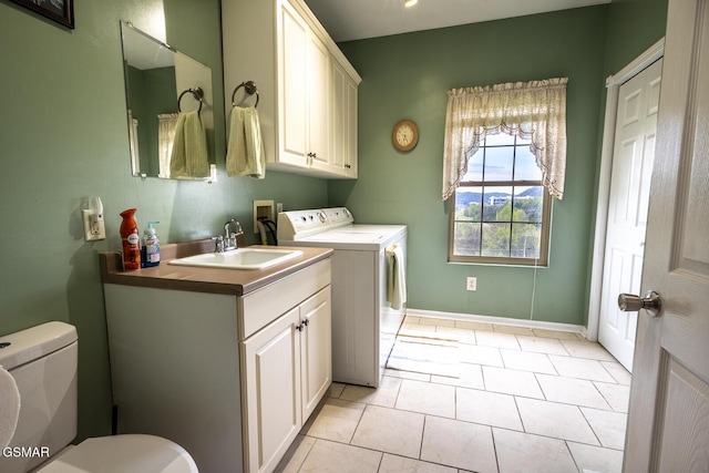 laundry room featuring separate washer and dryer, baseboards, light tile patterned flooring, laundry area, and a sink