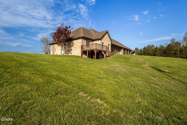 back of property featuring a yard, a wooden deck, and stairway