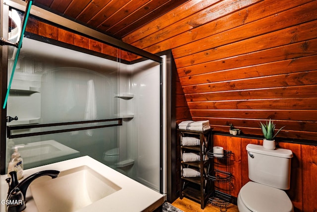 bathroom with wood walls, toilet, a stall shower, and wood ceiling