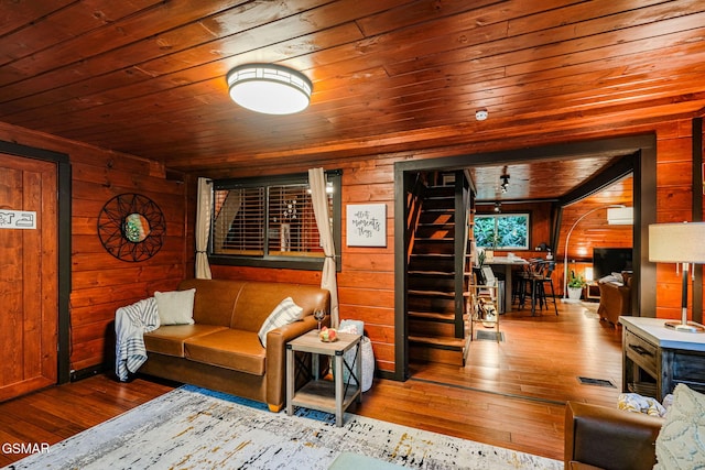 living area featuring hardwood / wood-style floors, wood walls, and wood ceiling