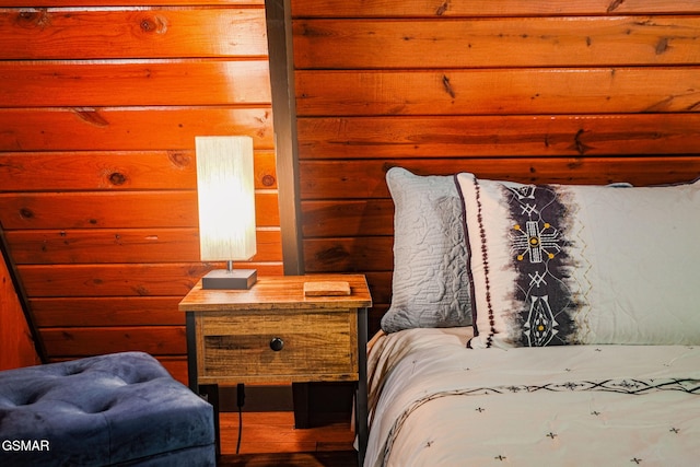 bedroom with wood walls and wood finished floors