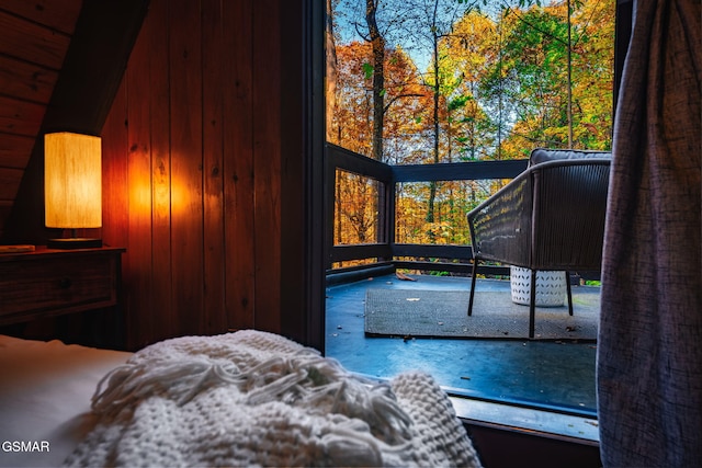 bedroom featuring wooden walls and multiple windows