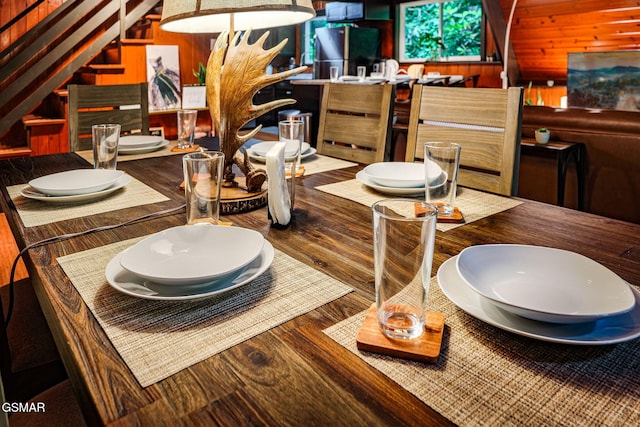 dining area with wood finished floors and wooden walls