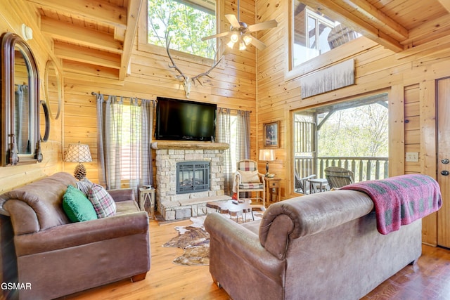 2867 White Oak Ridge Ln, Sevierville, TN 37862 - living area with wooden walls, plenty of natural light, a ceiling fan, a fireplace, and wood ceiling with exposed beams