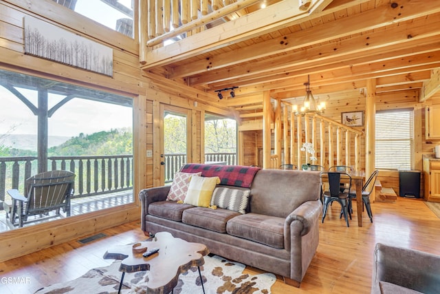 2867 White Oak Ridge Ln, Sevierville, TN 37862 - living area featuring a chandelier, wood walls, light wood finished floors, and beam ceiling