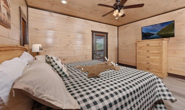bedroom featuring wooden walls, access to outside, a ceiling fan, wood finished floors, and wood ceiling