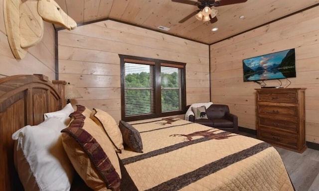 bedroom with wooden walls, wooden ceiling, wood finished floors, vaulted ceiling, and visible vents