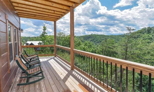wooden terrace featuring a forest view