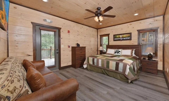 bedroom with wood walls, multiple windows, wood ceiling, and wood finished floors