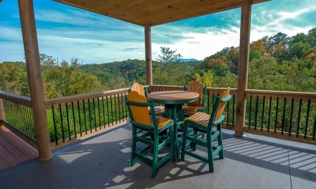 exterior space featuring outdoor dining area and a wooded view