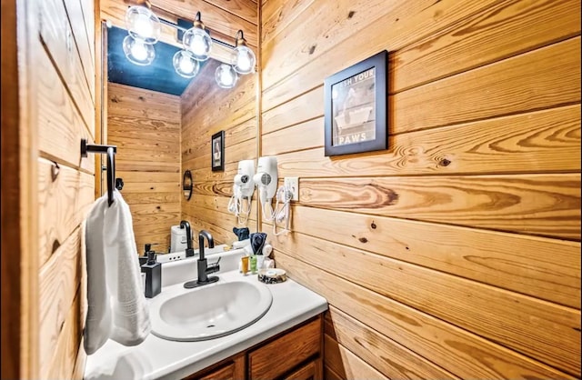 bathroom featuring vanity and wood walls