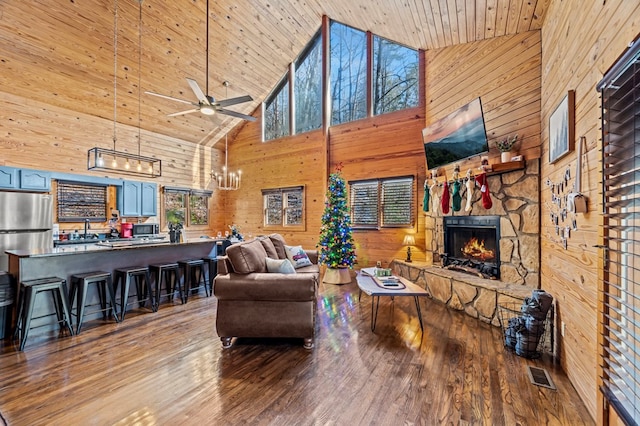 living room featuring ceiling fan, a fireplace, light hardwood / wood-style floors, high vaulted ceiling, and wooden ceiling