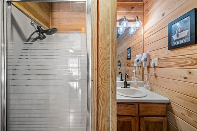 bathroom featuring vanity, a shower, and wooden walls