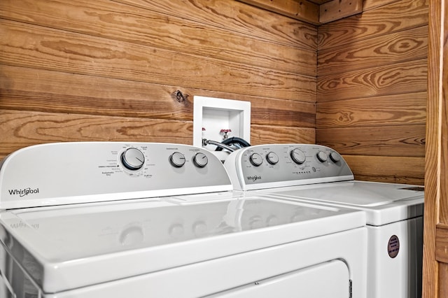 laundry room featuring separate washer and dryer and wooden walls