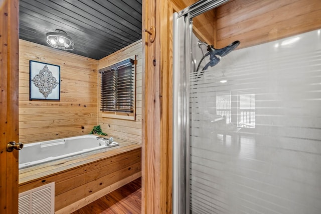 bathroom with wooden ceiling, wood-type flooring, wooden walls, and shower with separate bathtub