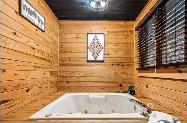 bathroom featuring a bathtub and wood walls