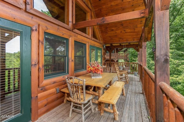 sunroom / solarium featuring lofted ceiling with beams and wood ceiling