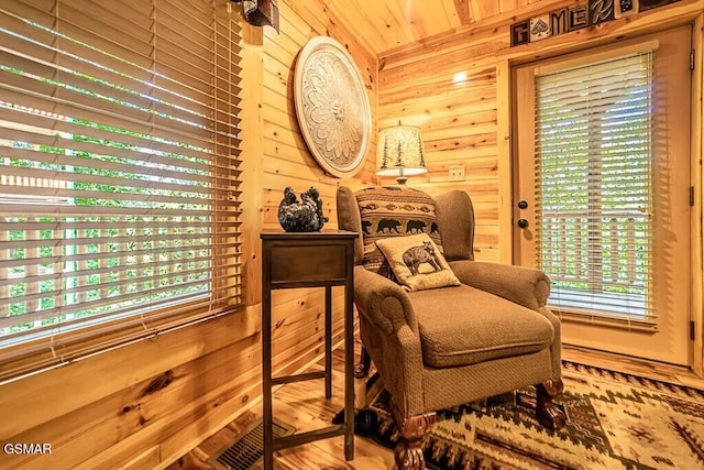 sitting room featuring wooden walls and wood ceiling