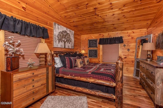 bedroom featuring wood ceiling, hardwood / wood-style floors, vaulted ceiling, and wooden walls