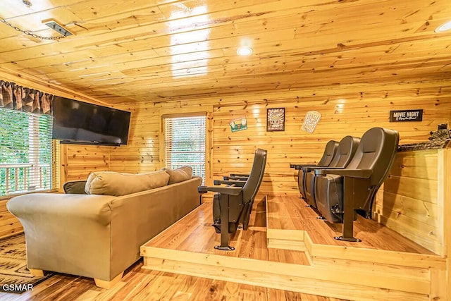 living room with light hardwood / wood-style floors, wood ceiling, and wood walls