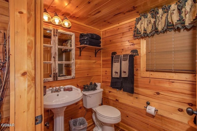 bathroom with toilet, wooden walls, and wood ceiling