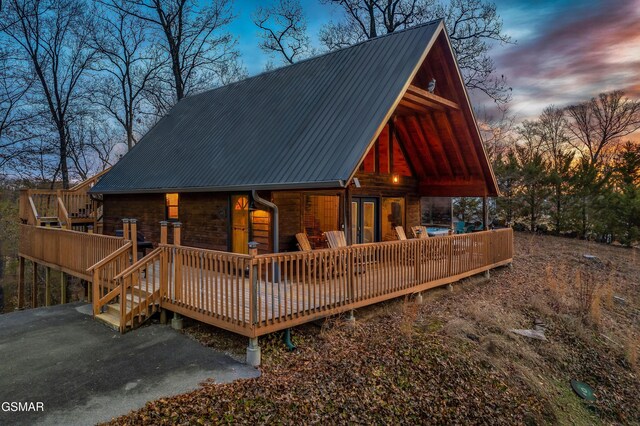 back of property at dusk featuring a deck and metal roof