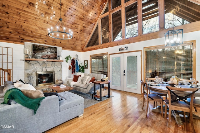 living room featuring wooden ceiling, wood finished floors, an inviting chandelier, french doors, and a fireplace