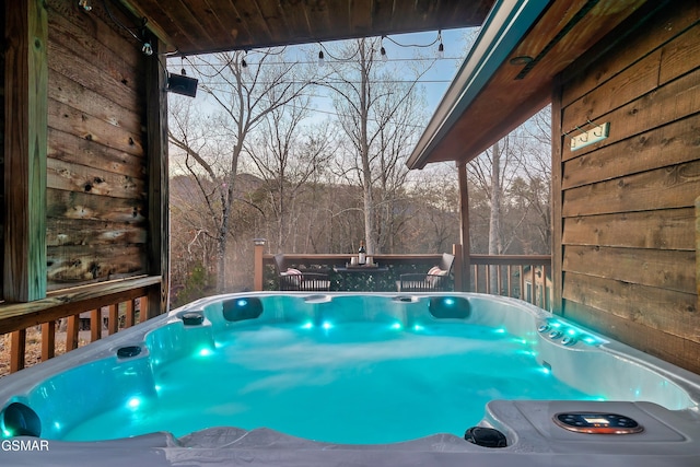 view of swimming pool featuring a deck and a hot tub