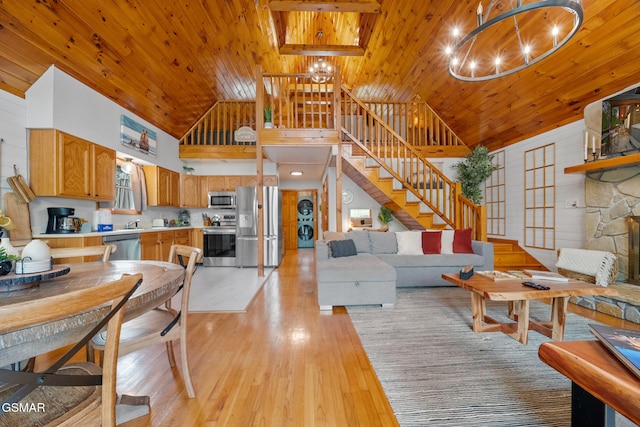 living area featuring stairway, light wood finished floors, wood ceiling, high vaulted ceiling, and a notable chandelier
