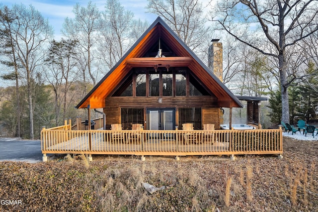 back of house with a chimney, a deck, and french doors