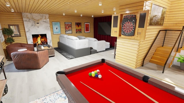 recreation room featuring wooden walls, wooden ceiling, wood finished floors, pool table, and a fireplace