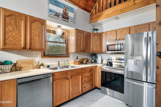 kitchen with stainless steel appliances, marble finish floor, light countertops, and a sink