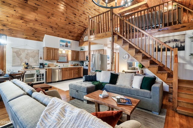 living room with high vaulted ceiling, wooden ceiling, light wood finished floors, and stairs