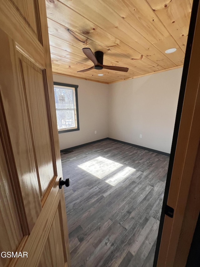 unfurnished bedroom with ceiling fan, dark wood finished floors, wood ceiling, and baseboards