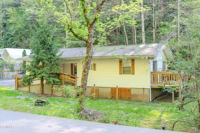 250 Cartertown Rd, Gatlinburg, TN 37738 - view of front of house with a wooded view, a front lawn, covered porch, a fire pit, and metal roof