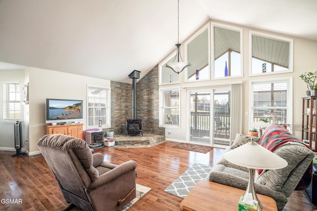 living room with high vaulted ceiling, a wood stove, and wood-type flooring